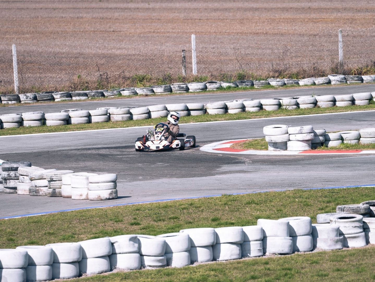 Go-kart turning through a tire-lined track corner and apex
